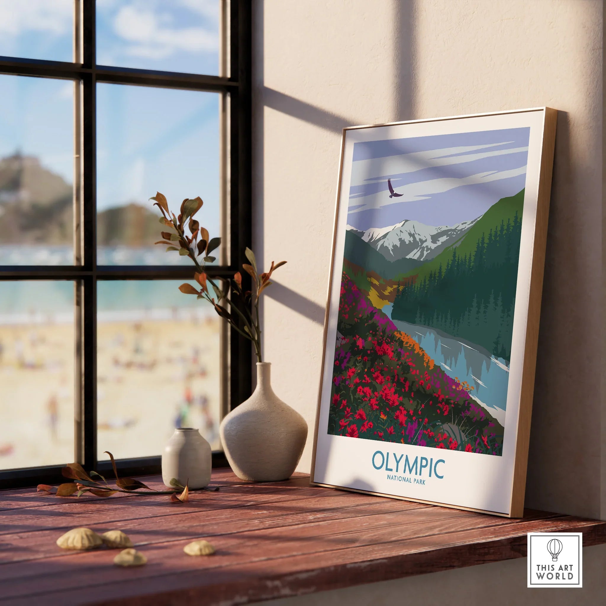Framed Olympic National Park art print on windowsill with vases and beach view outside