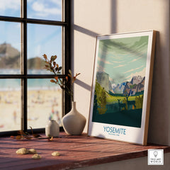 Yosemite National Park art print in natural wood frame on windowsill with vases and beach view.
