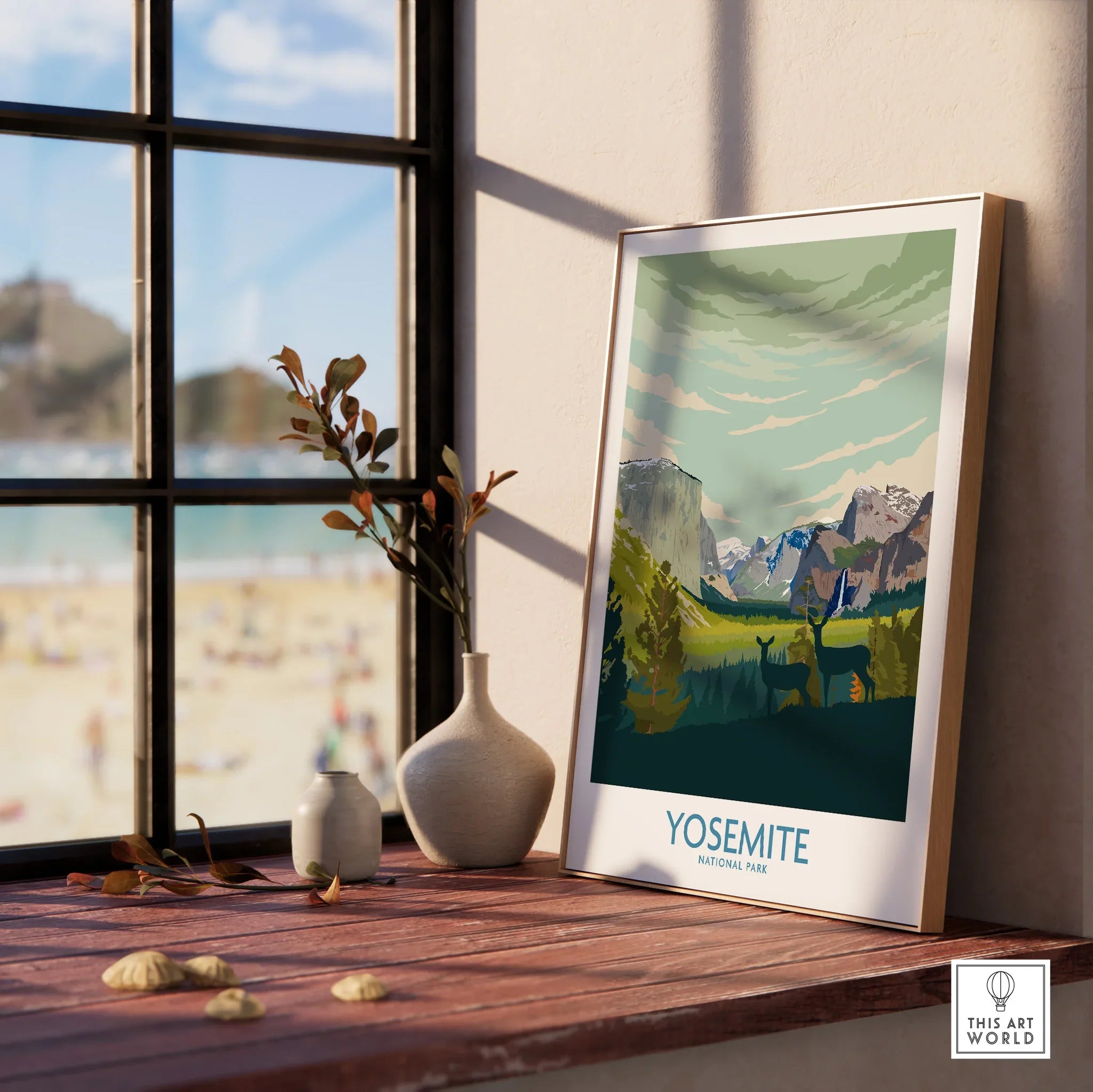 Yosemite National Park art print in natural wood frame on windowsill with vases and beach view.