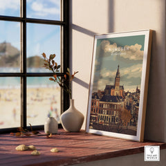 Framed Nijmegen cityscape travel poster on windowsill with ceramic vases and beach view.