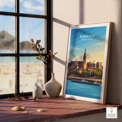 Framed Nijmegen Netherlands cityscape art print by a window, with vases and beach view.