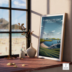Framed Pembrokeshire Coast National Park travel poster on windowsill with vases and beach view