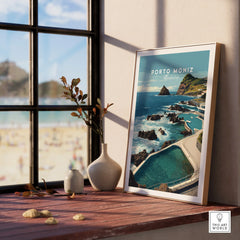 Framed Porto Moniz Madeira travel poster on window ledge with ocean view and decor vases