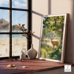 Richmond Park deer art print in natural wood frame on sunny windowsill, vases beside it