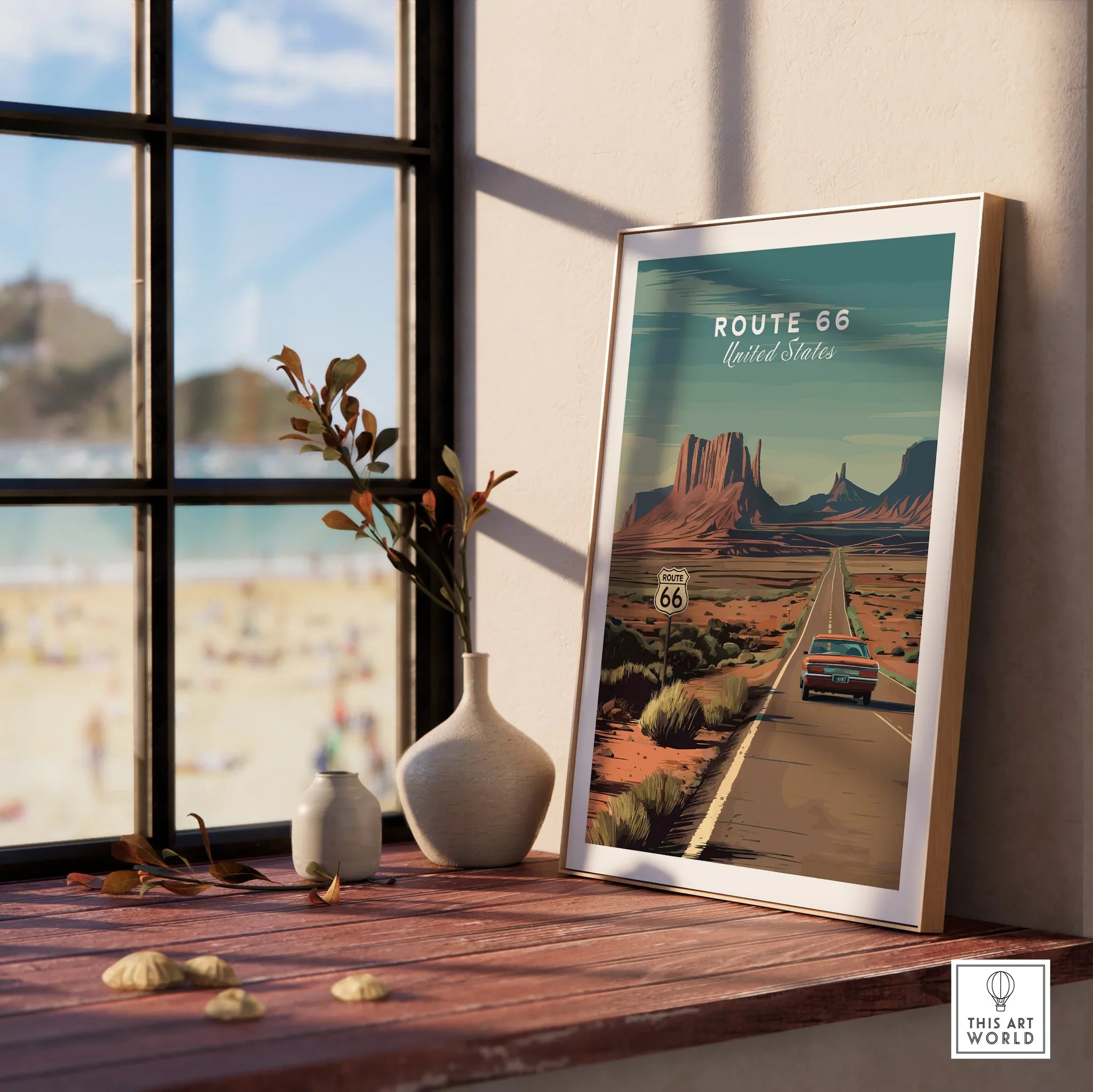 Framed Route 66 travel poster with desert landscape on a wooden window sill, beach view outside.