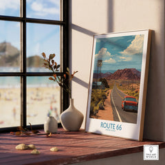Framed Route 66 travel poster on windowsill with vases, scenic road and vintage car art
