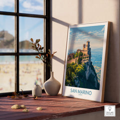 San Marino Poster | Canvas Print displayed on a shelf near a window with a view of beach scenery.