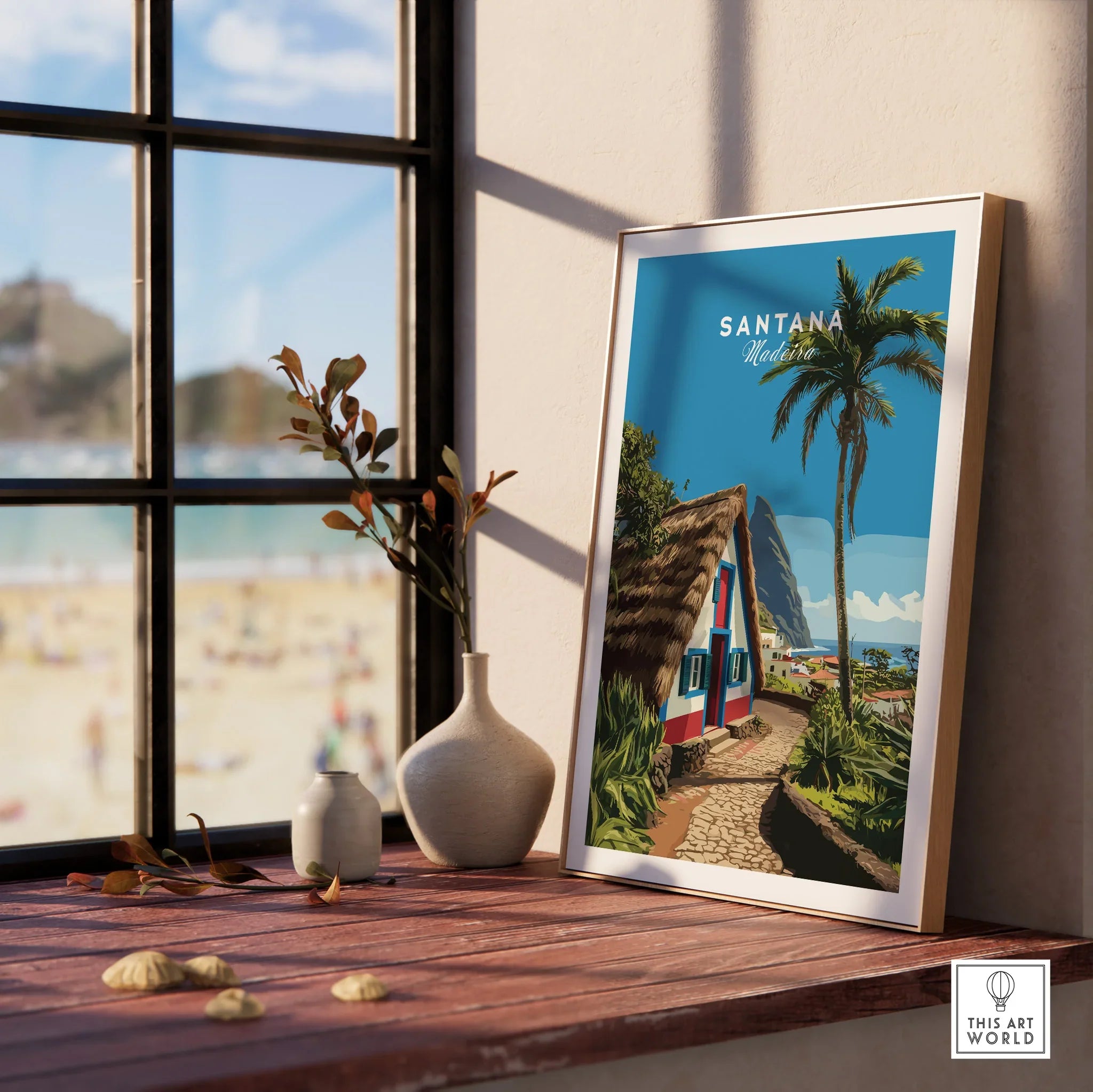 Santana Madeira travel art print in natural wood frame on window sill, beach view outside