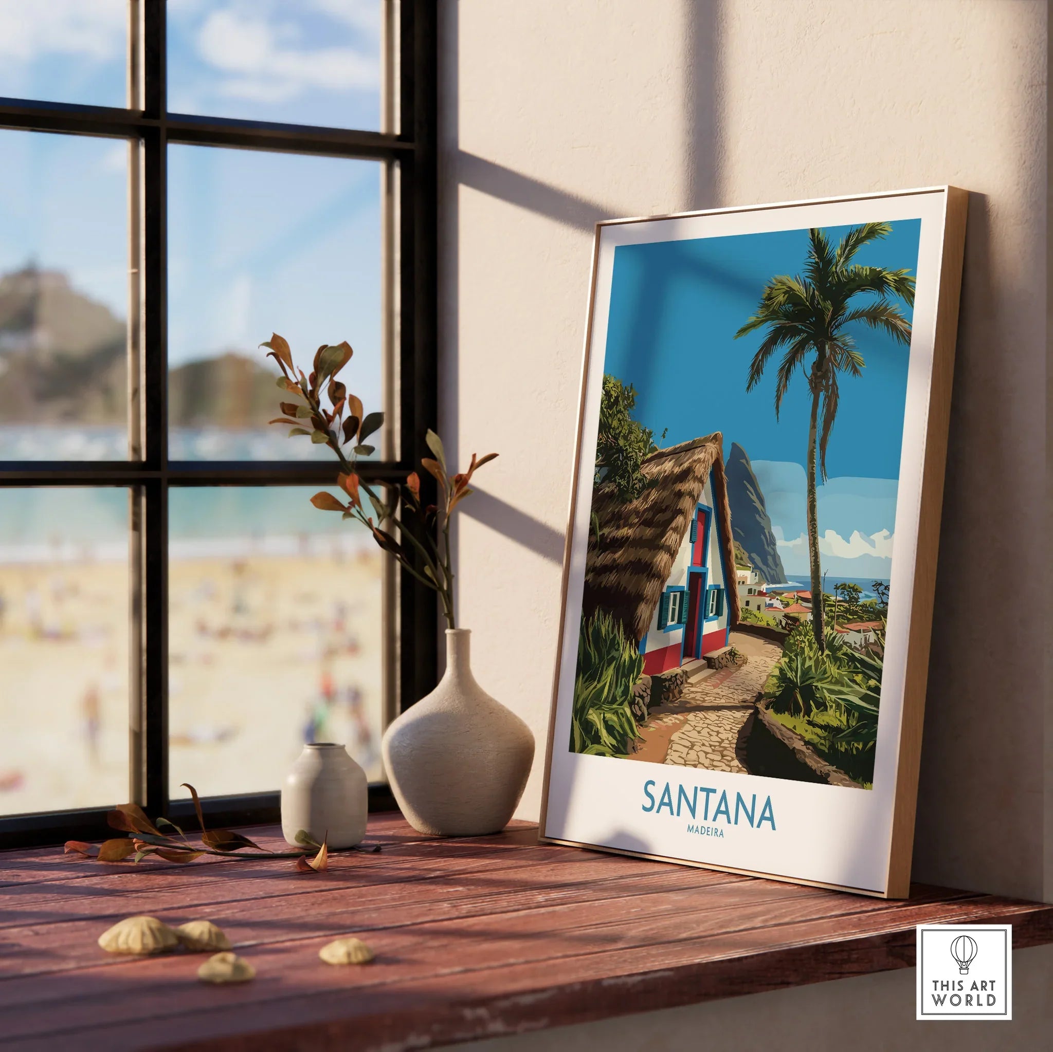 Framed Santana Madeira travel poster with natural wood frame on windowsill, beach outside window