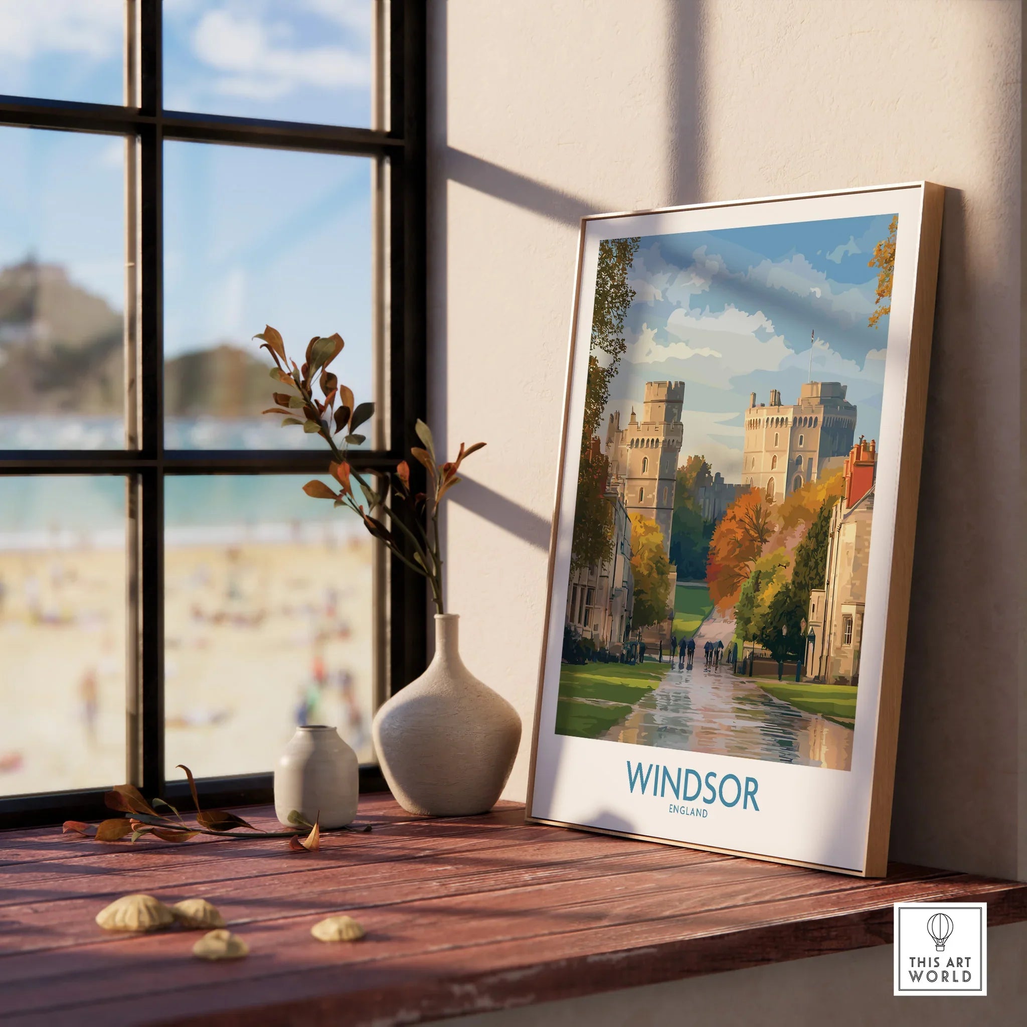 Framed Windsor travel poster with natural wood frame on windowsill, beach view outside