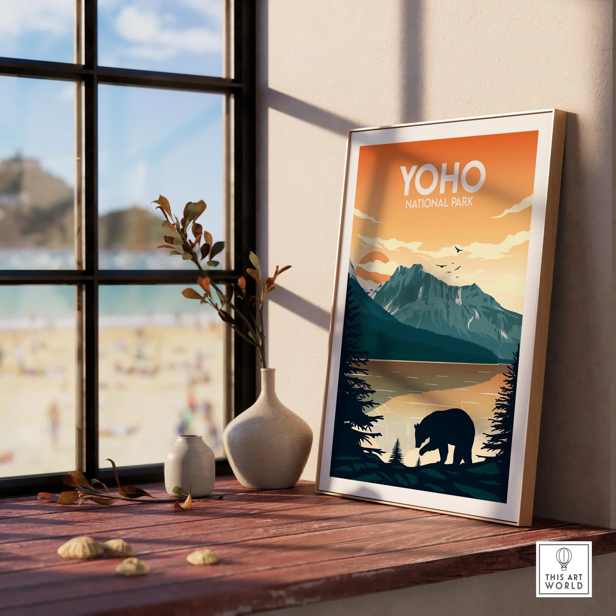 Framed Yoho National Park print with mountain, bear, and lake on a windowsill with vases.