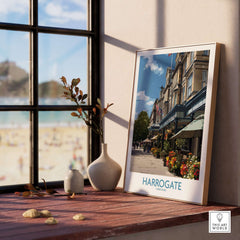 Harrogate Yorkshire Art Print | Floral Cafe Scene Poster displayed on a wooden table by a window with beach view.