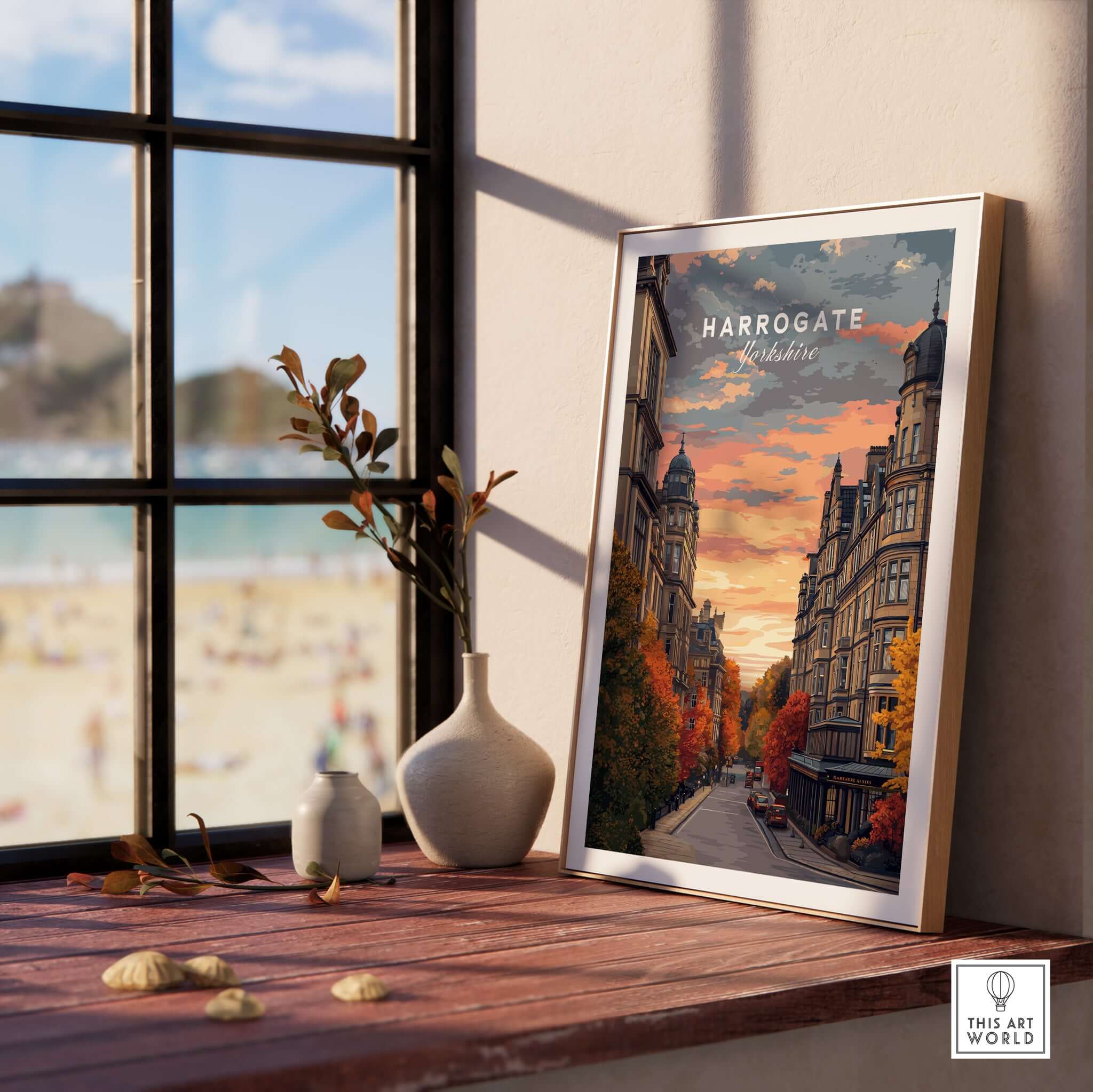 Harrogate Print | English Travel Wall Decor displayed on a wooden table with stylish decor and a beach view.