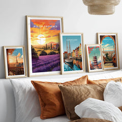 Aix-en-Provence Print in a gallery wall set of five framed travel prints in natural wood frames above a bed