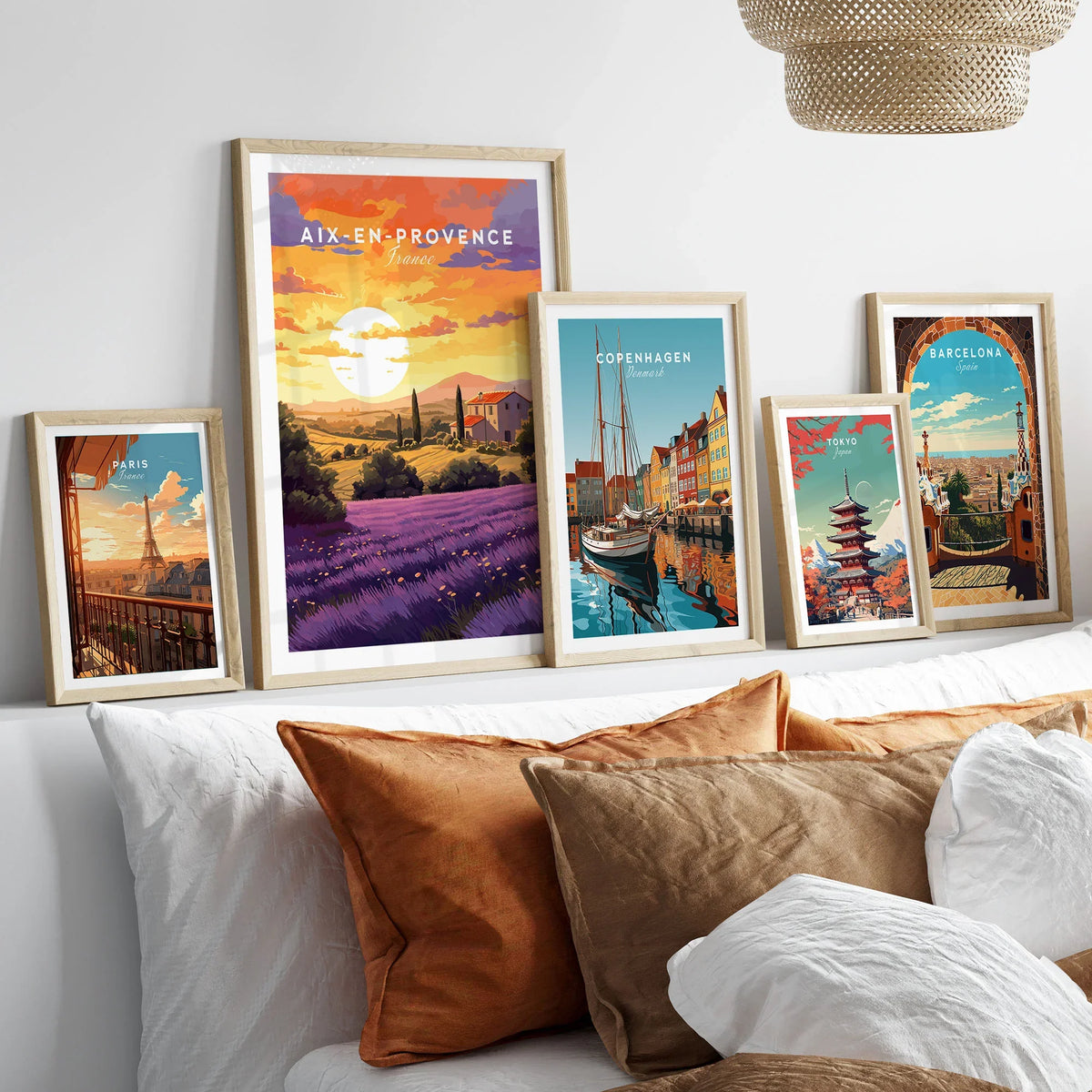 Aix-en-Provence Print in a gallery wall set of five framed travel prints in natural wood frames above a bed