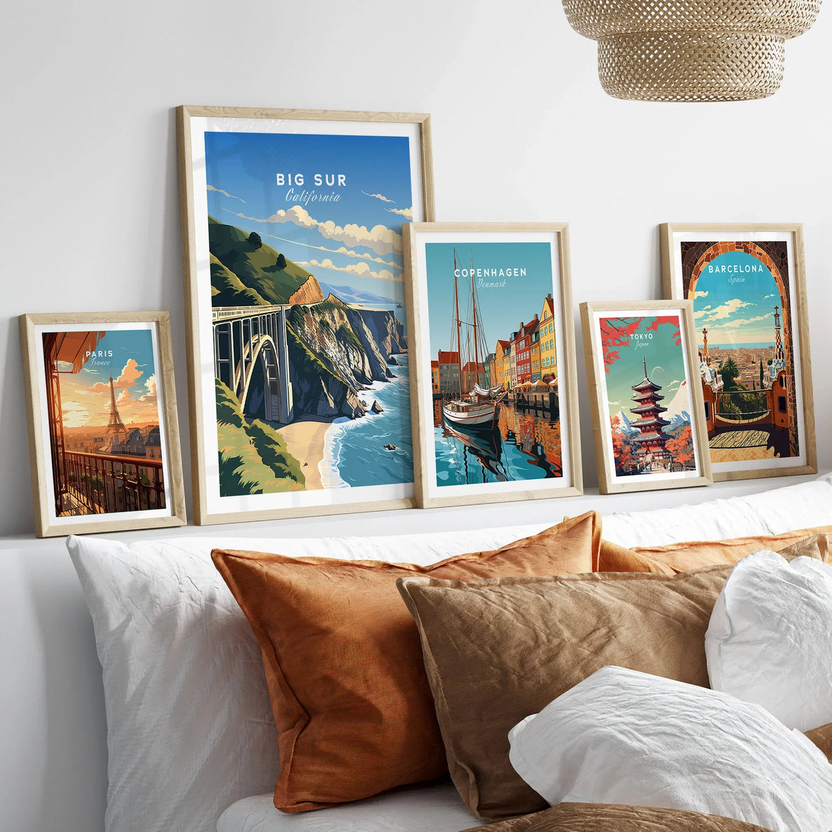 Big Sur Print in a gallery wall set of five framed travel prints in natural wood frames above a bed