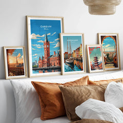 Cardiff Travel Poster in a gallery wall set of five framed travel prints in natural wood frames above a bed