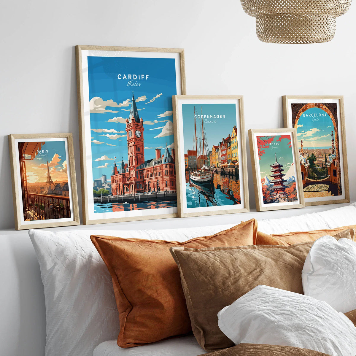 Cardiff Travel Poster in a gallery wall set of five framed travel prints in natural wood frames above a bed