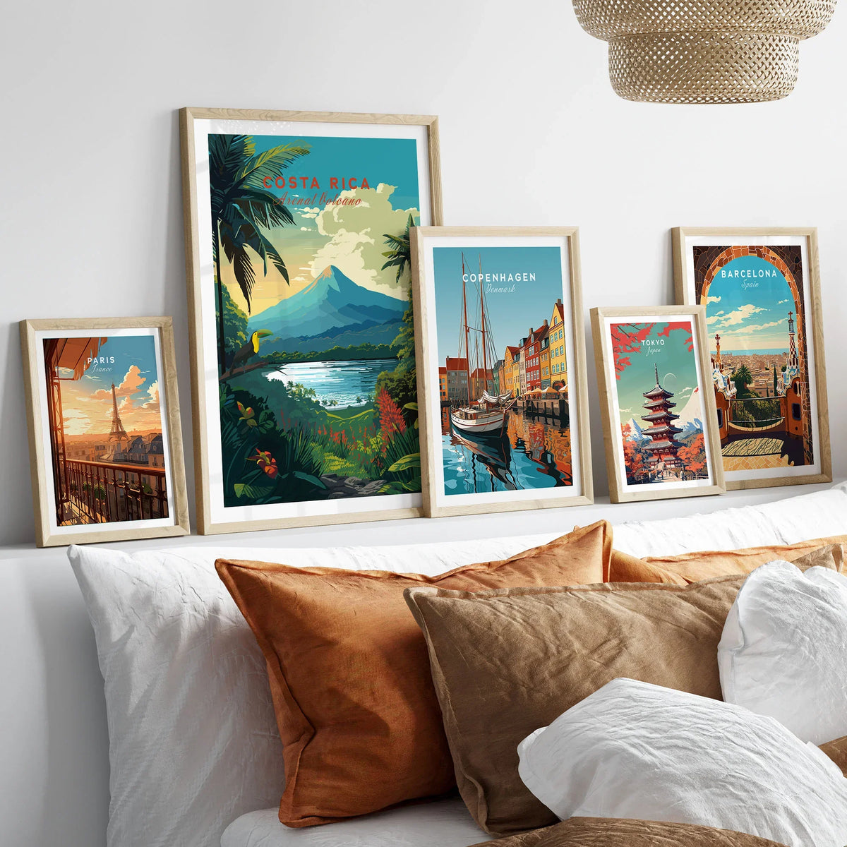 Costa Rica Print in a gallery wall set of five framed travel prints in natural wood frames above a bed