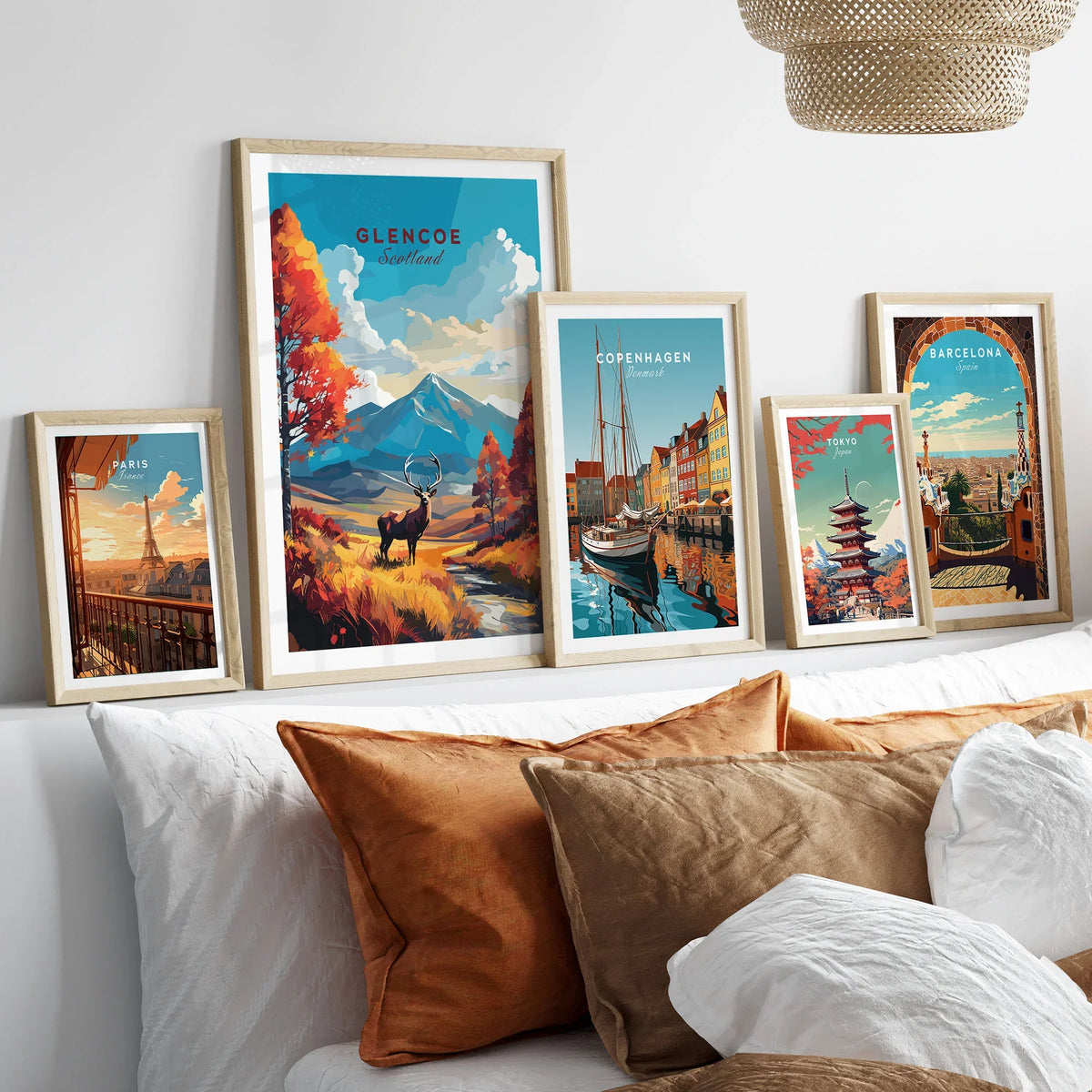 Glencoe Art Print in a gallery wall set of five framed travel prints in natural wood frames above a bed