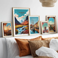 Glencoe Poster Print in a gallery wall set of five framed travel prints in natural wood frames above a bed