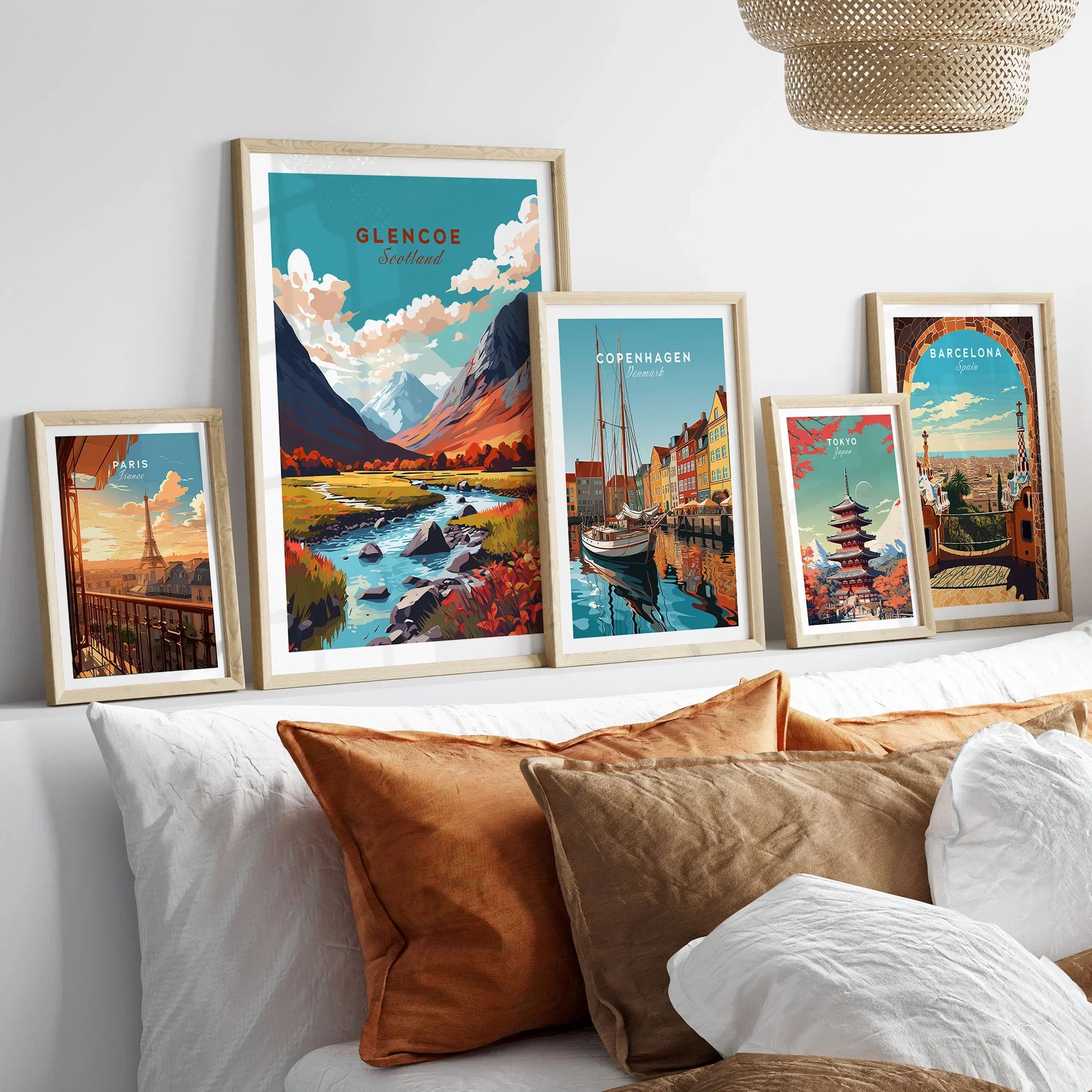Glencoe Poster Print in a gallery wall set of five framed travel prints in natural wood frames above a bed