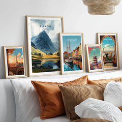 Glencoe Travel Print in a gallery wall set of five framed travel prints in natural wood frames above a bed