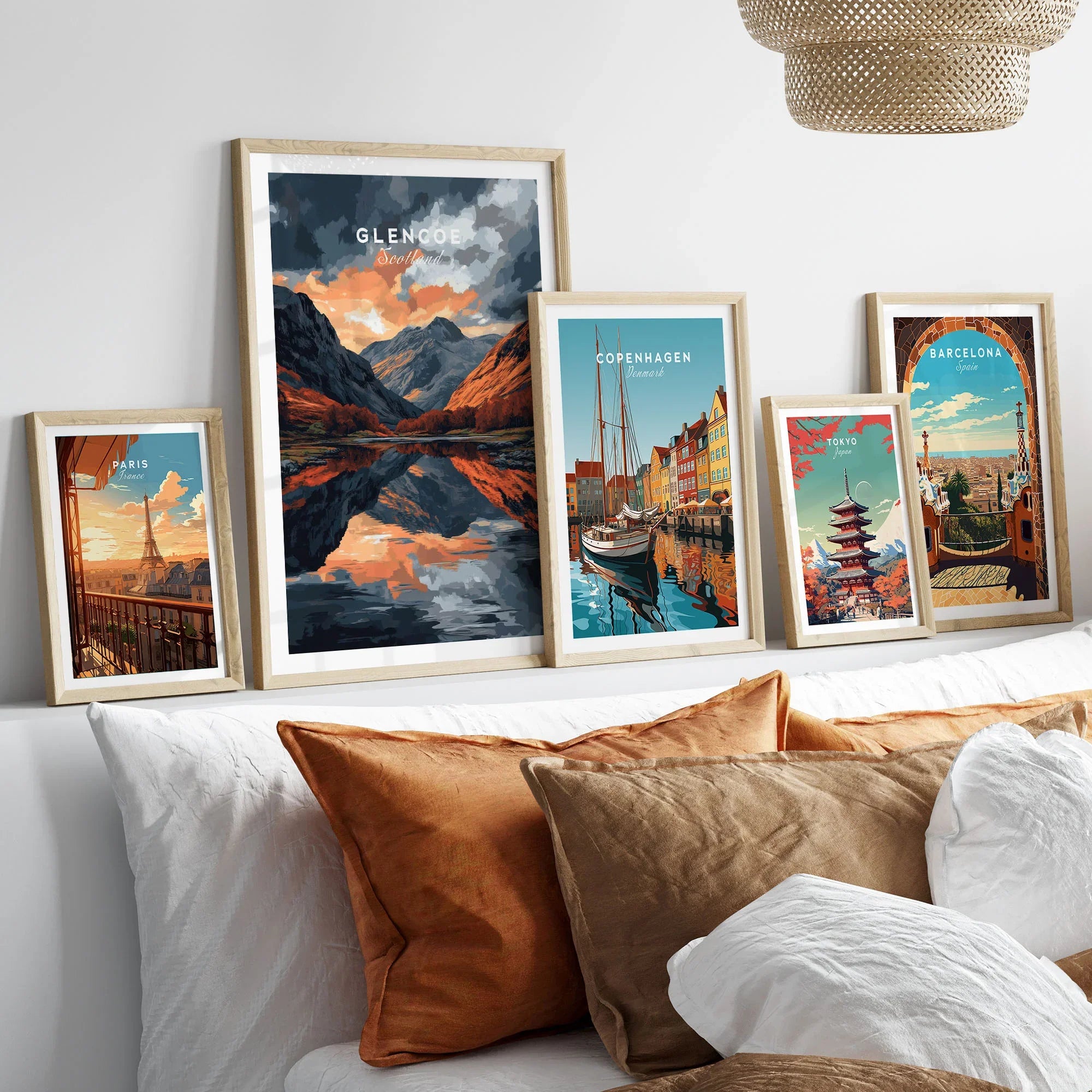 Glencoe Wall Art in a gallery wall set of five framed travel prints in natural wood frames above a bed