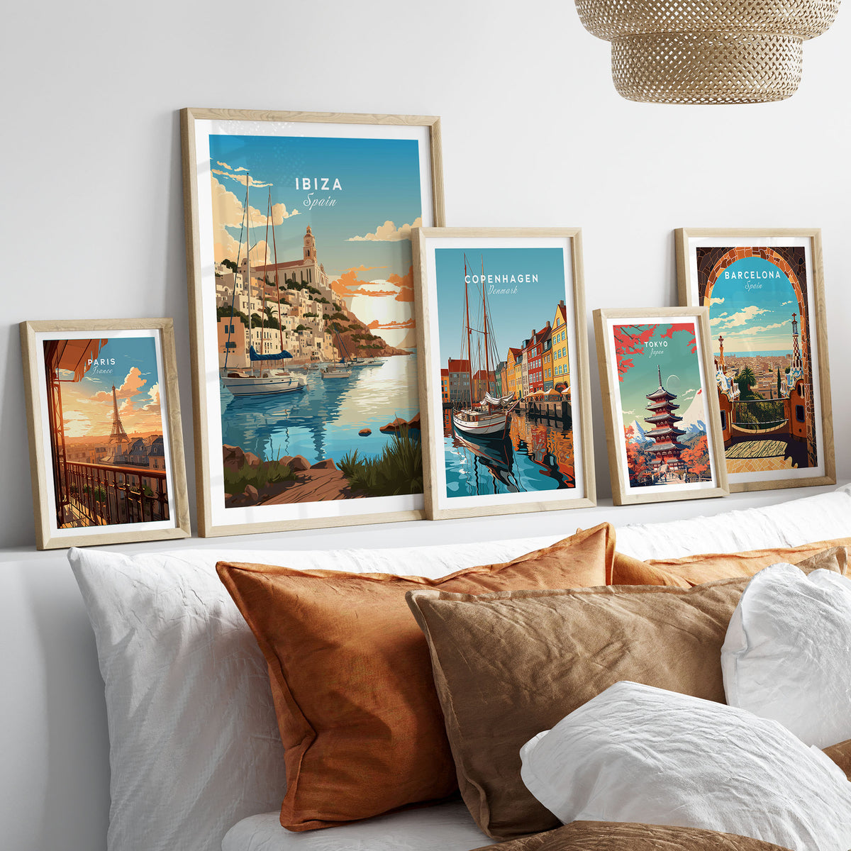 Ibiza Poster Print in a gallery wall set of five framed travel prints in natural wood frames above a bed