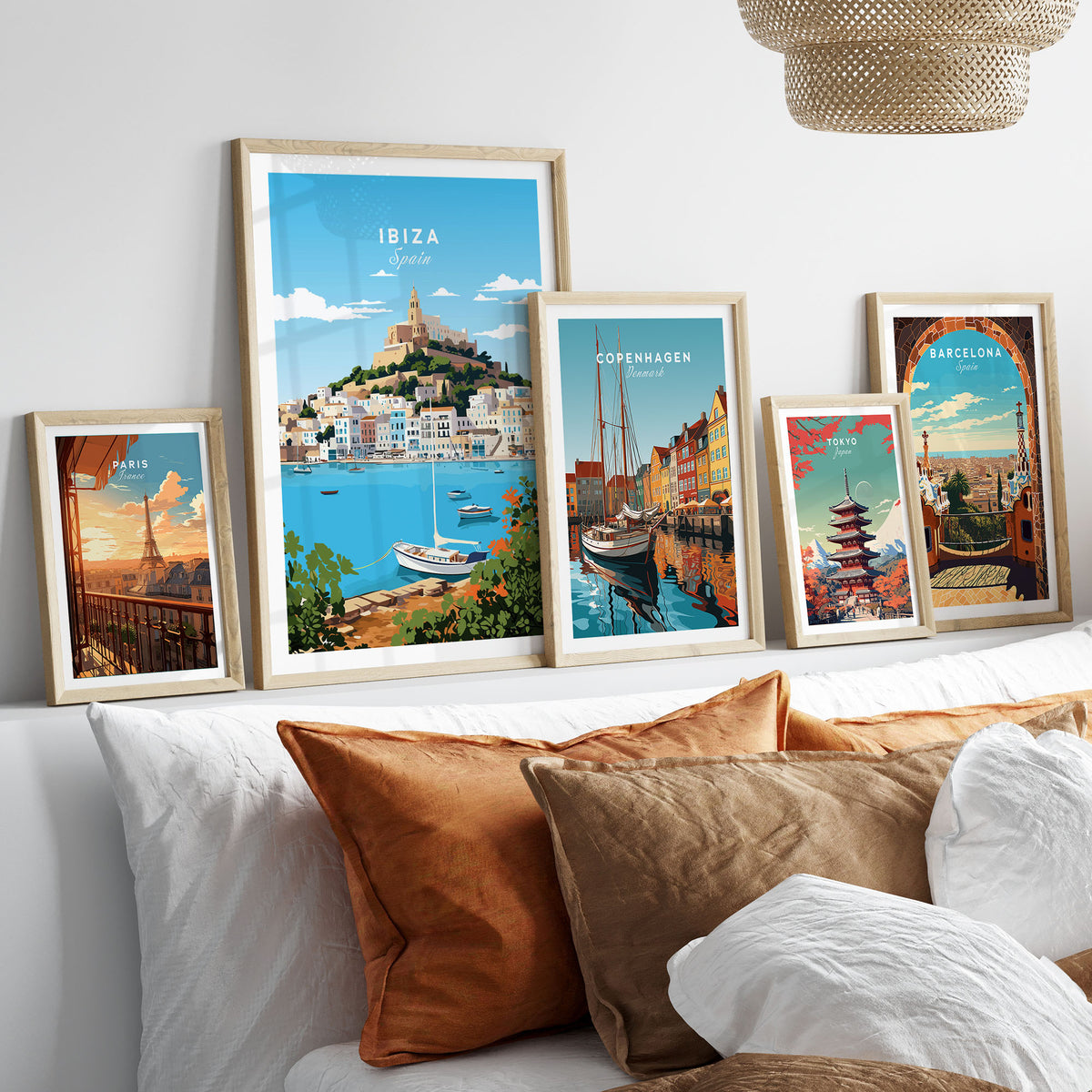 Ibiza Print in a gallery wall set of five framed travel prints in natural wood frames above a bed