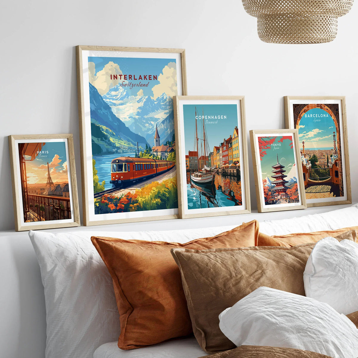 Interlaken Travel Print in a gallery wall set of five framed travel prints in natural wood frames above a bed
