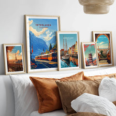 Interlaken Wall Art in a gallery wall set of five framed travel prints in natural wood frames above a bed