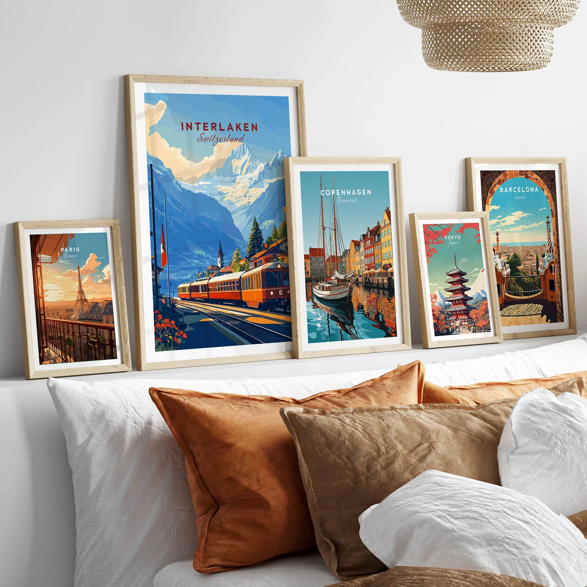 Interlaken Wall Art in a gallery wall set of five framed travel prints in natural wood frames above a bed