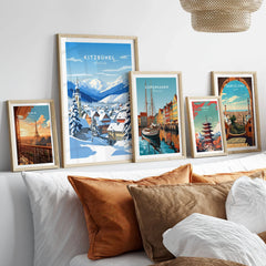 Kitzbuhel Poster in a gallery wall set of five framed travel prints in natural wood frames above a bed