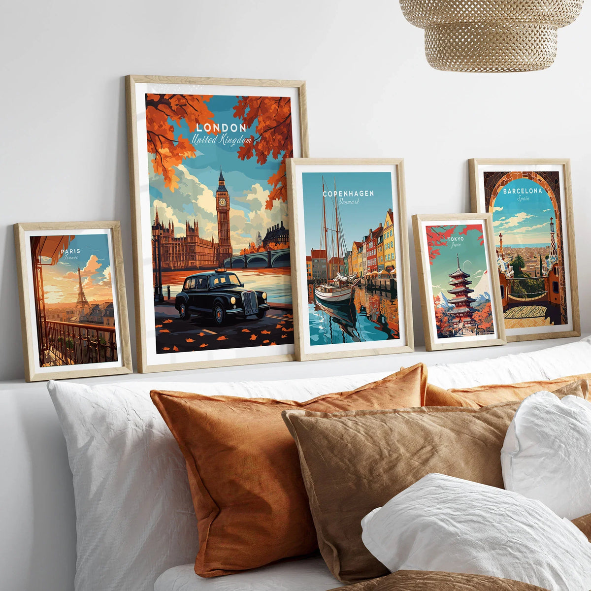 London Wall Art in a gallery wall set of five framed travel prints in natural wood frames above a bed