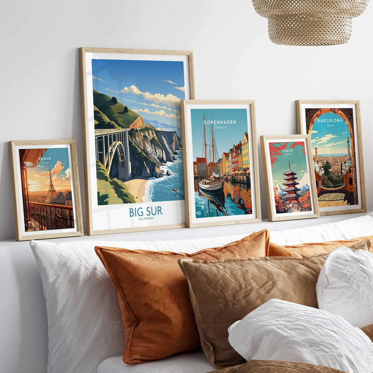 Big Sur Wall Art | Modern Style in a gallery wall set of five framed travel prints in natural wood frames above a bed
