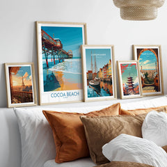 Cocoa Beach Pier Poster - Florida Beach Travel Decor in a gallery wall set of five framed travel prints in natural wood frames above a bed