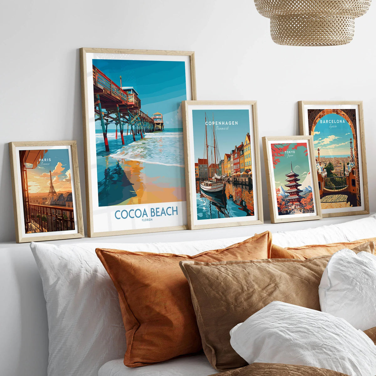Cocoa Beach Pier Poster - Florida Beach Travel Decor in a gallery wall set of five framed travel prints in natural wood frames above a bed