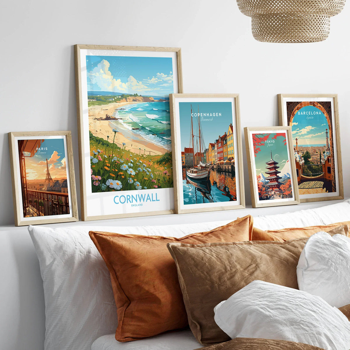 Cornwall Wall Art | Modern Style in a gallery wall set of five framed travel prints in natural wood frames above a bed