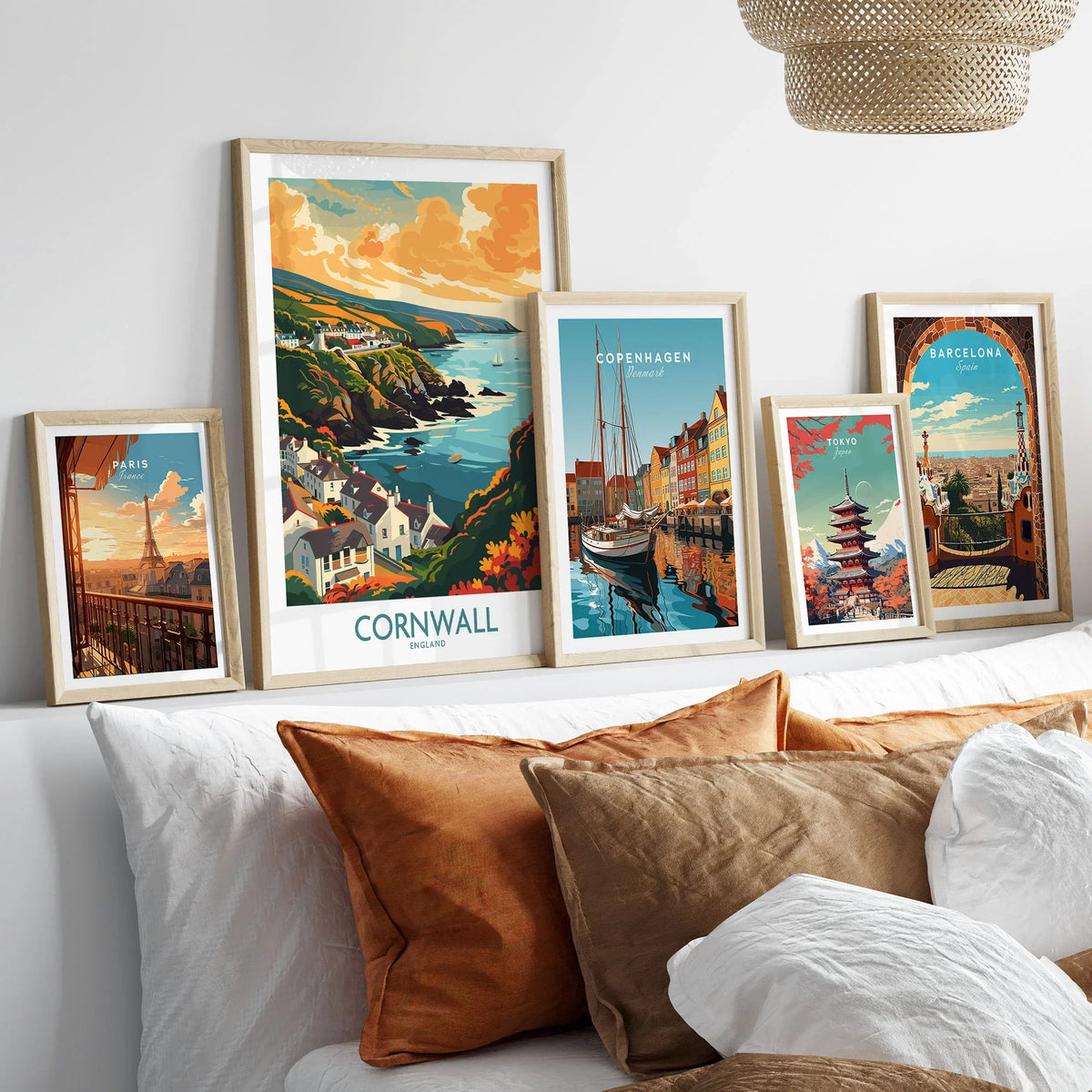 Cornwall Art Print - Modern in a gallery wall set of five framed travel prints in natural wood frames above a bed