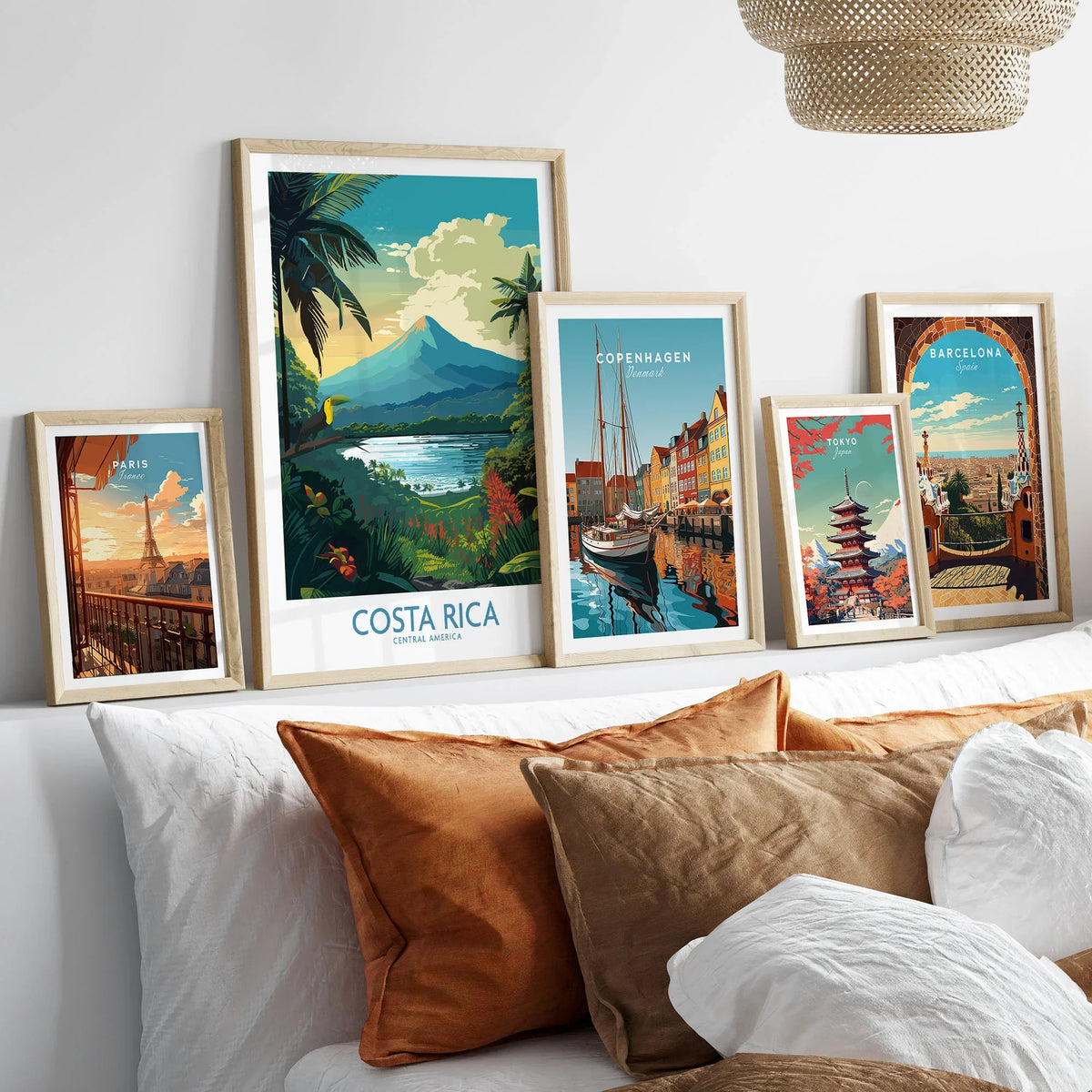 Costa Rica Wall Art | Modern Style in a gallery wall set of five framed travel prints in natural wood frames above a bed