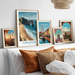 Durdle Door Art Print Dorset Wall Art in a gallery wall set of five framed travel prints in natural wood frames above a bed