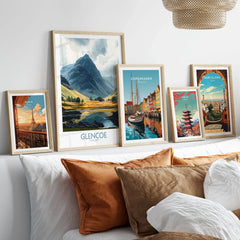 Glencoe Travel Poster in a gallery wall set of five framed travel prints in natural wood frames above a bed