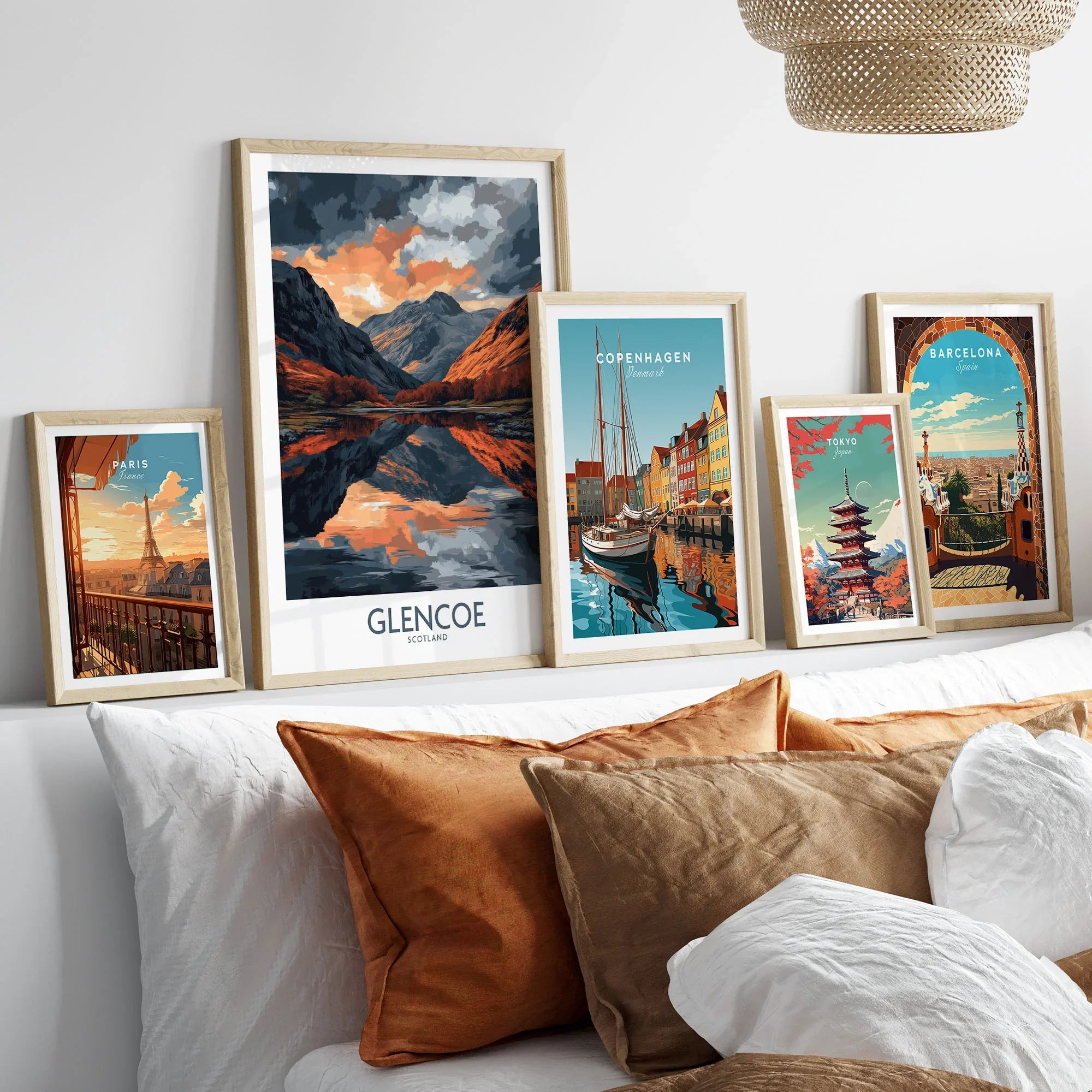 Glencoe Wall Art Poster in a gallery wall set of five framed travel prints in natural wood frames above a bed
