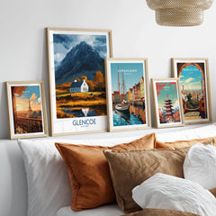 Glencoe Scotland Print in a gallery wall set of five framed travel prints in natural wood frames above a bed