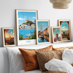 Ibiza Poster in a gallery wall set of five framed travel prints in natural wood frames above a bed