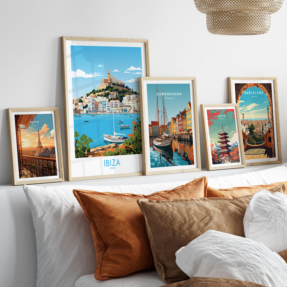 Ibiza Poster in a gallery wall set of five framed travel prints in natural wood frames above a bed