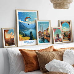 Interlaken Wall Art Print in a gallery wall set of five framed travel prints in natural wood frames above a bed