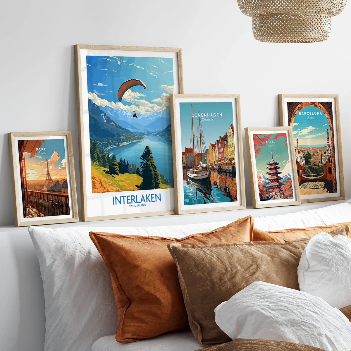 Interlaken Wall Art Print in a gallery wall set of five framed travel prints in natural wood frames above a bed