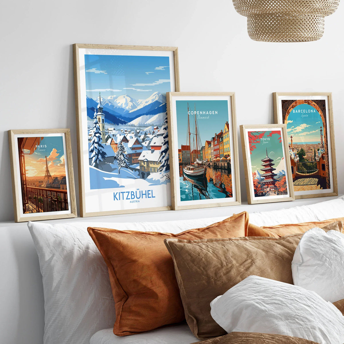 Kitzbuhel Austria Art Print in a gallery wall set of five framed travel prints in natural wood frames above a bed
